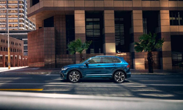 auto azzurro elettrico parcheggiata strada palazzo marrone